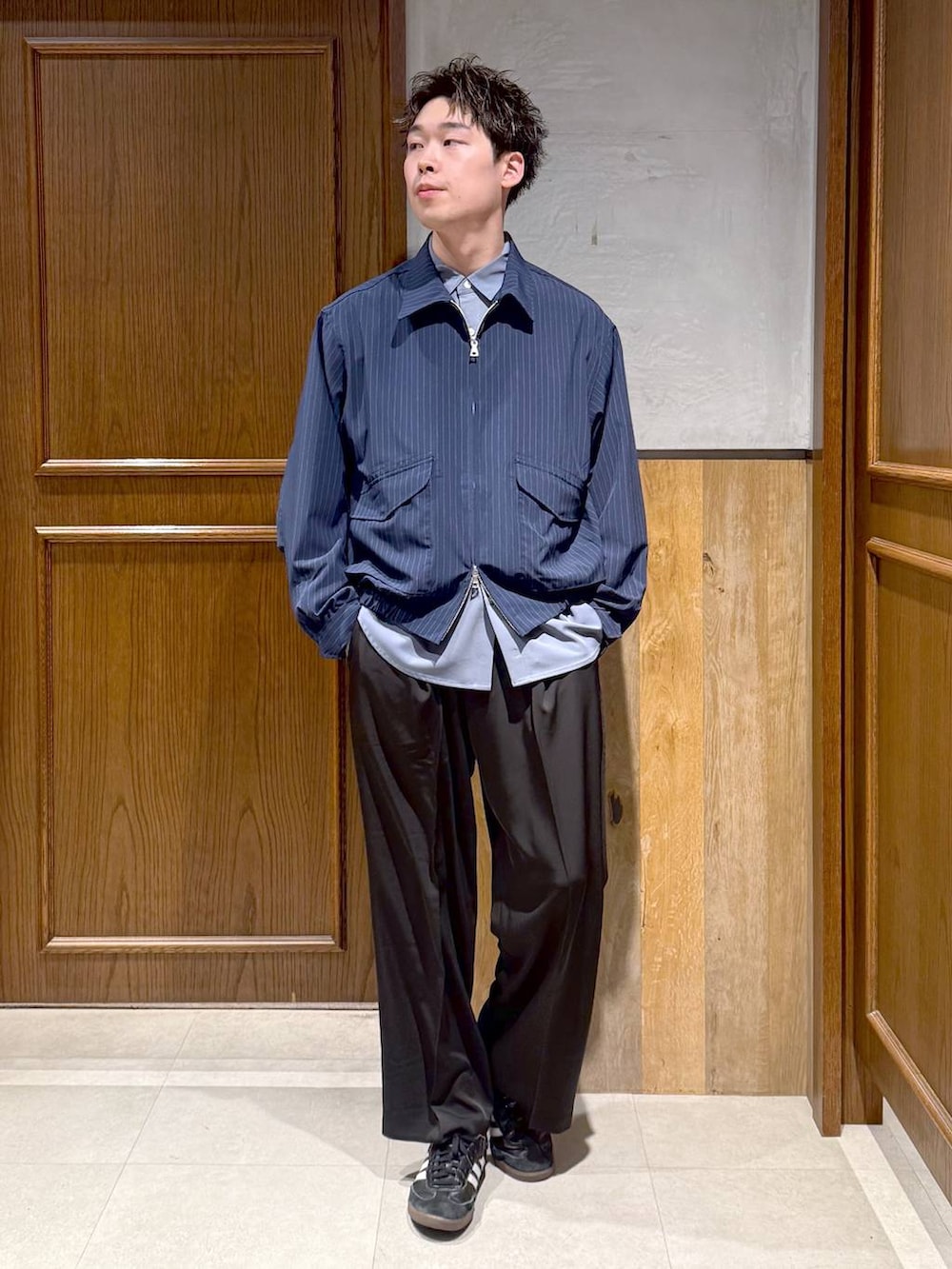 ブルー系のシャツ/ブラウス、ブラック系のスラックス、ブルー系のブルゾンを着用したメンズの春コーディネートの3枚目の写真