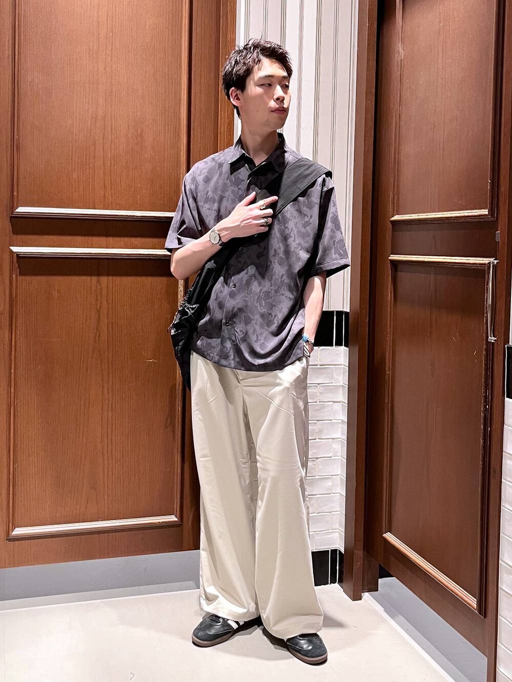 ホワイト系のスラックス、ブラック系のシャツ/ブラウス、ブラック系のショルダーバッグを着用したメンズの夏コーディネートの3枚目の写真