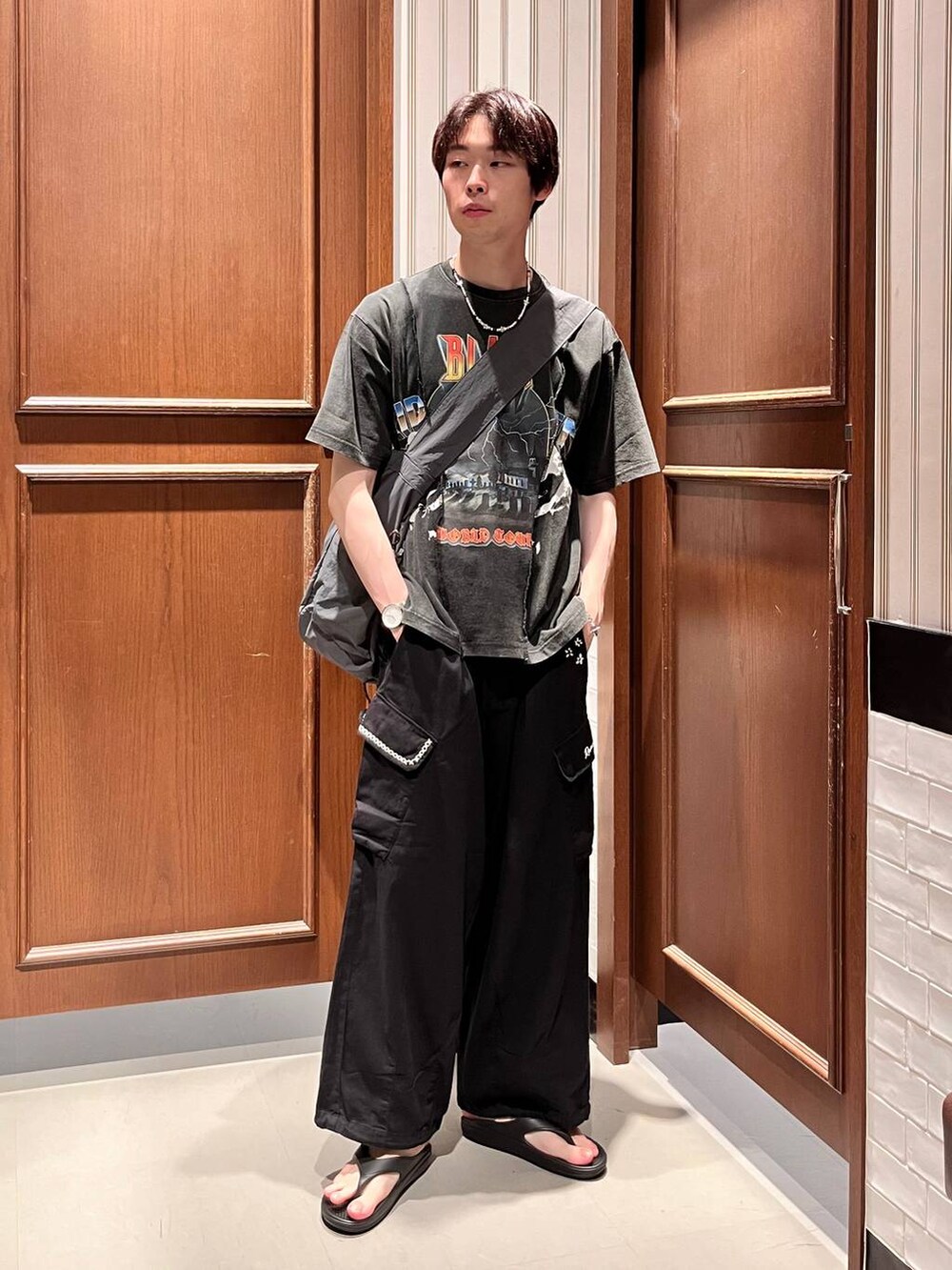 ブラック系のサンダル、ブラック系のカーゴパンツ、グレー系のショルダーバッグを着用したメンズの夏コーディネートの2枚目の写真