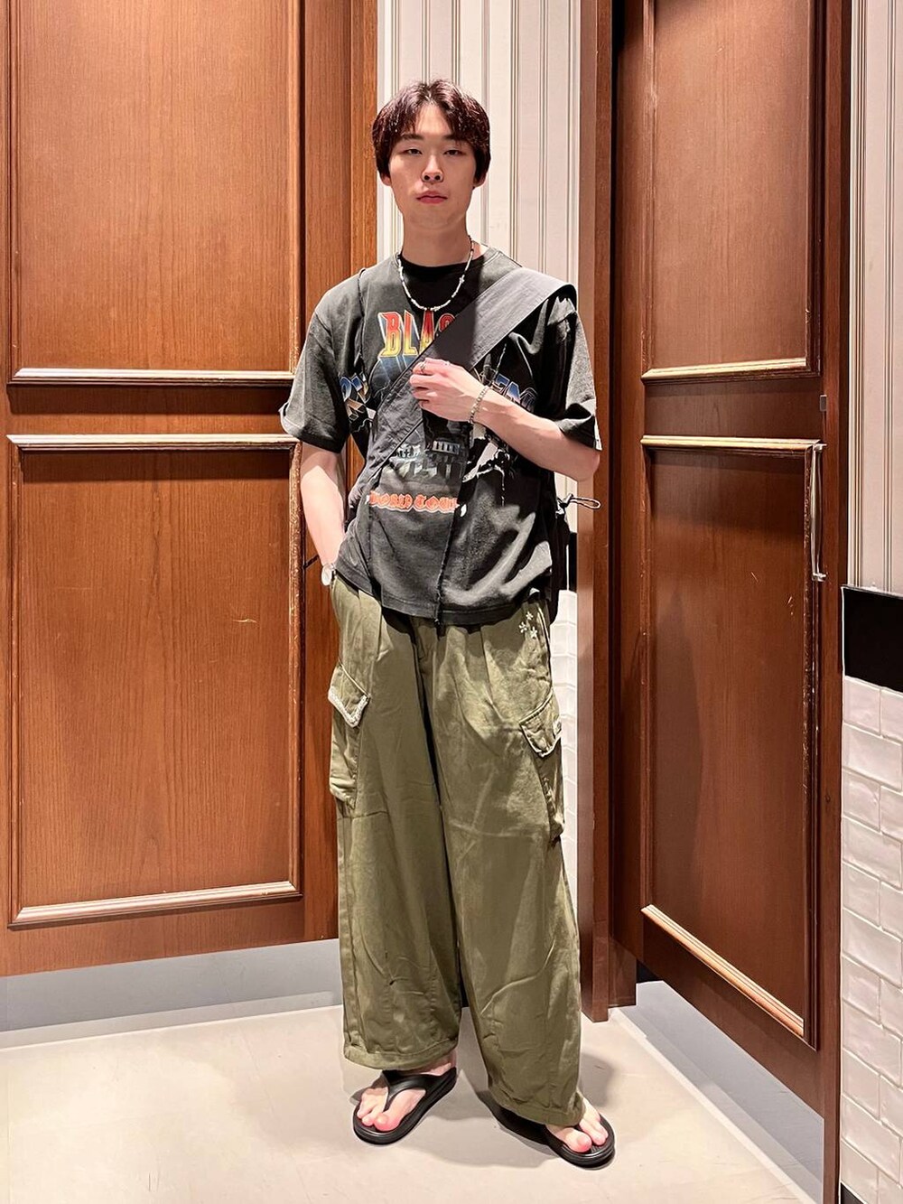 ブラック系のサンダル、グリーン系のカーゴパンツ、グレー系のショルダーバッグを着用したメンズの夏コーディネートの2枚目の写真
