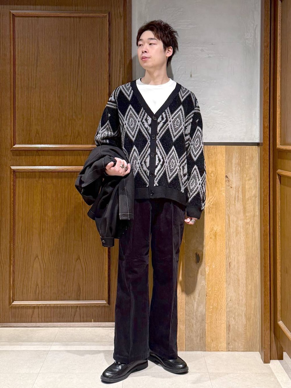 ブラック系のスラックス、ブラック系のブルゾン、ブラック系のカーディガン/ボレロを着用したメンズの秋コーディネートの2枚目の写真