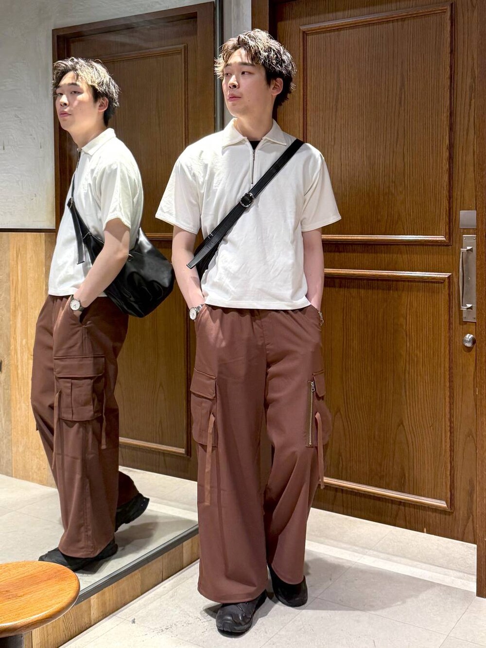 ブラック系のショルダーバッグ、イエロー系のスラックス、ホワイト系のTシャツ/カットソーを着用したメンズの春コーディネートの3枚目の写真