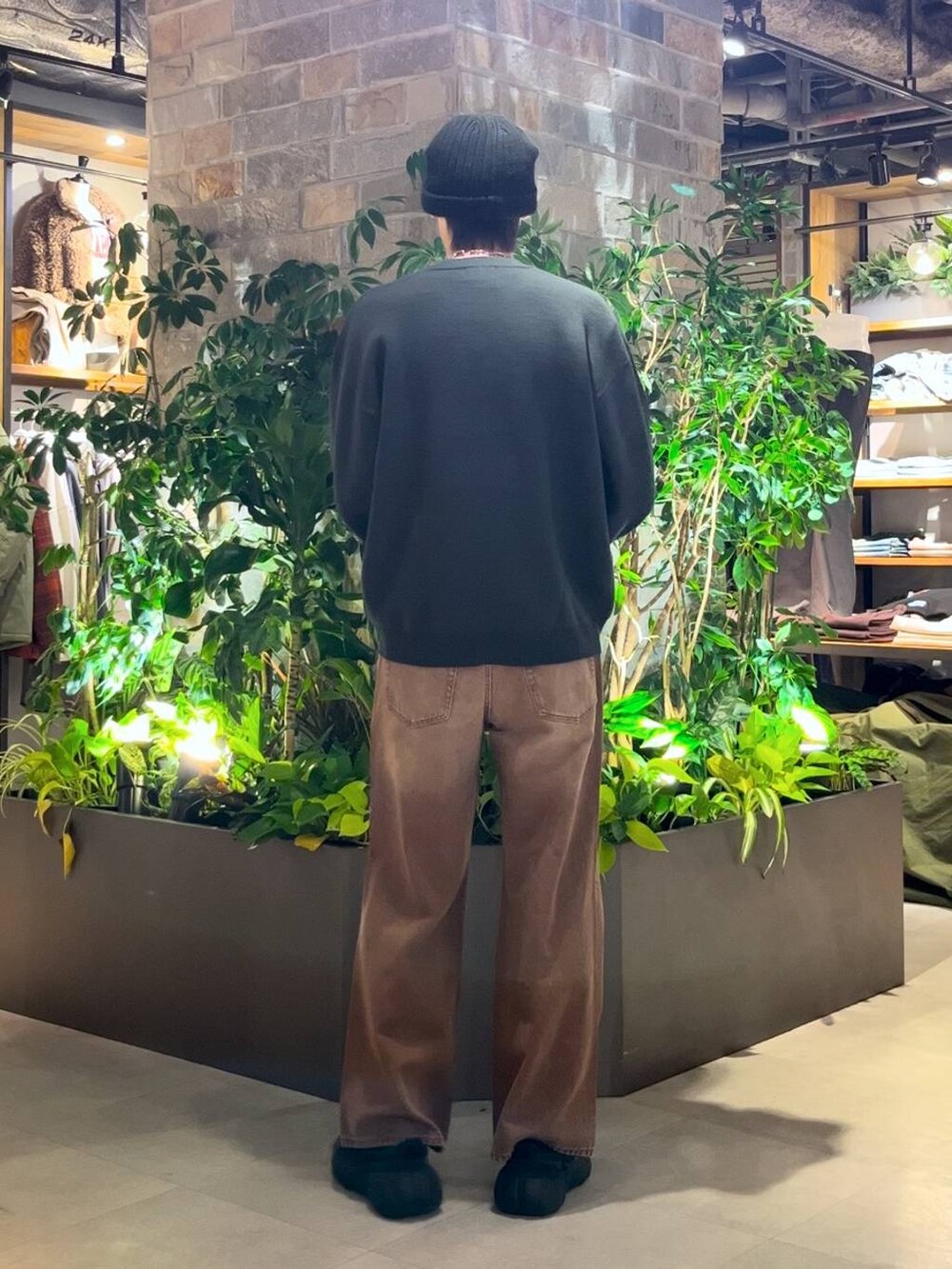 ブラウン系のデニムパンツ、グリーン系のニット/セーターを着用したメンズの冬コーディネートの4枚目の写真