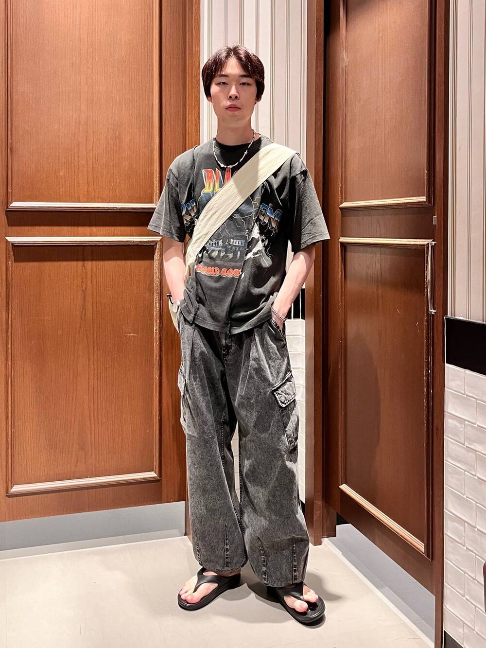 ブラック系のサンダル、グレー系のデニムパンツ、ホワイト系のショルダーバッグを着用したメンズの夏コーディネートの6枚目の写真