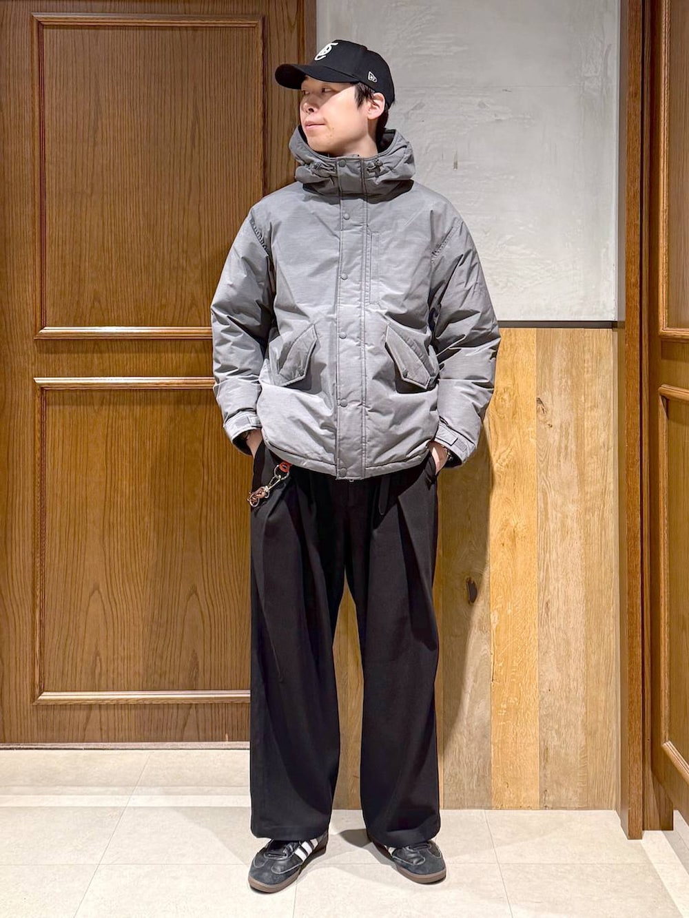 グレー系のダウンジャケット/コート、ブラック系のスラックス、レッド系のスウェットを着用したメンズの冬コーディネートの3枚目の写真