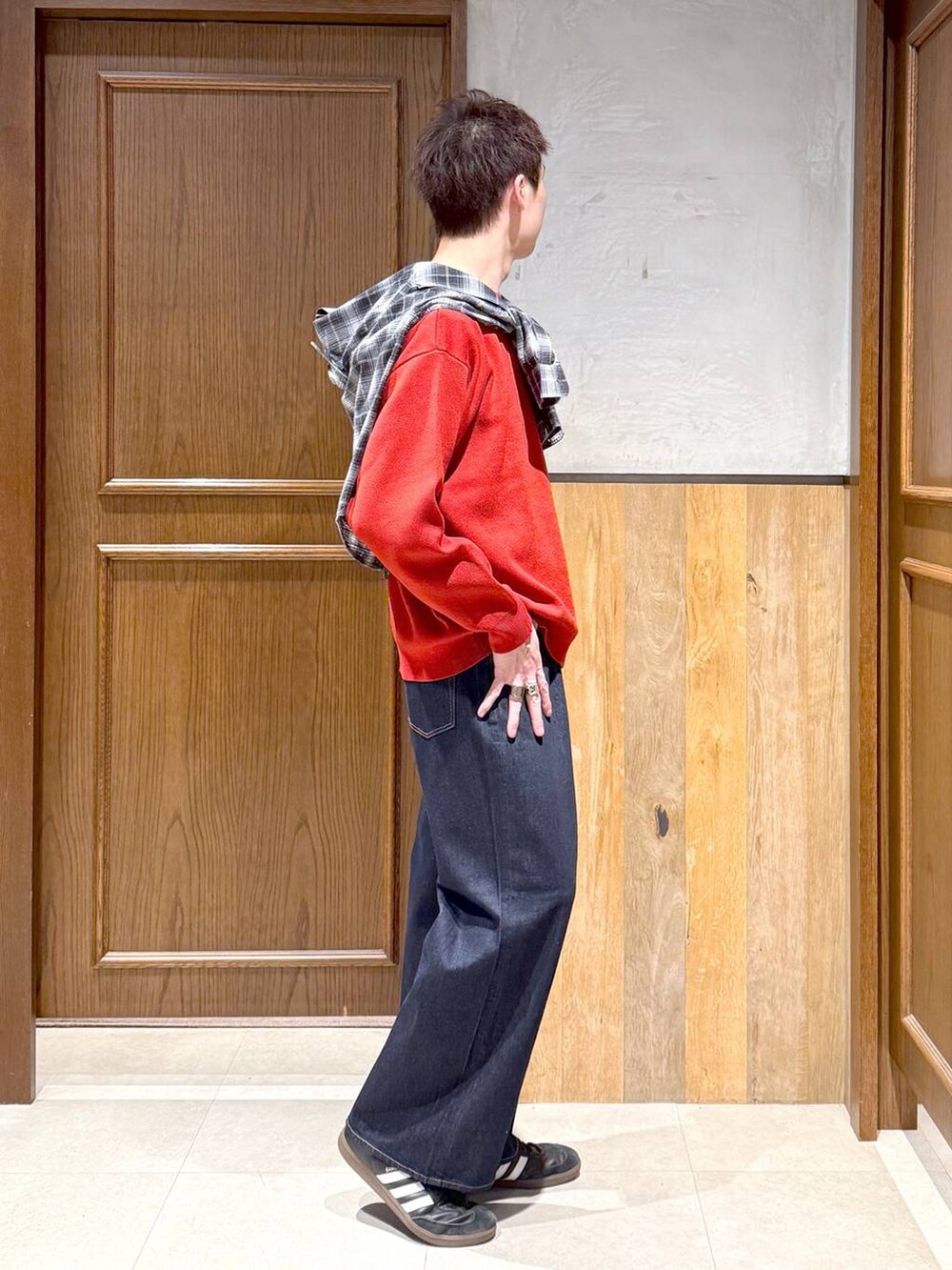 ブラック系のシャツ/ブラウス、ブルー系のデニムパンツ、レッド系のニット/セーターを着用したメンズの秋コーディネートの4枚目の写真