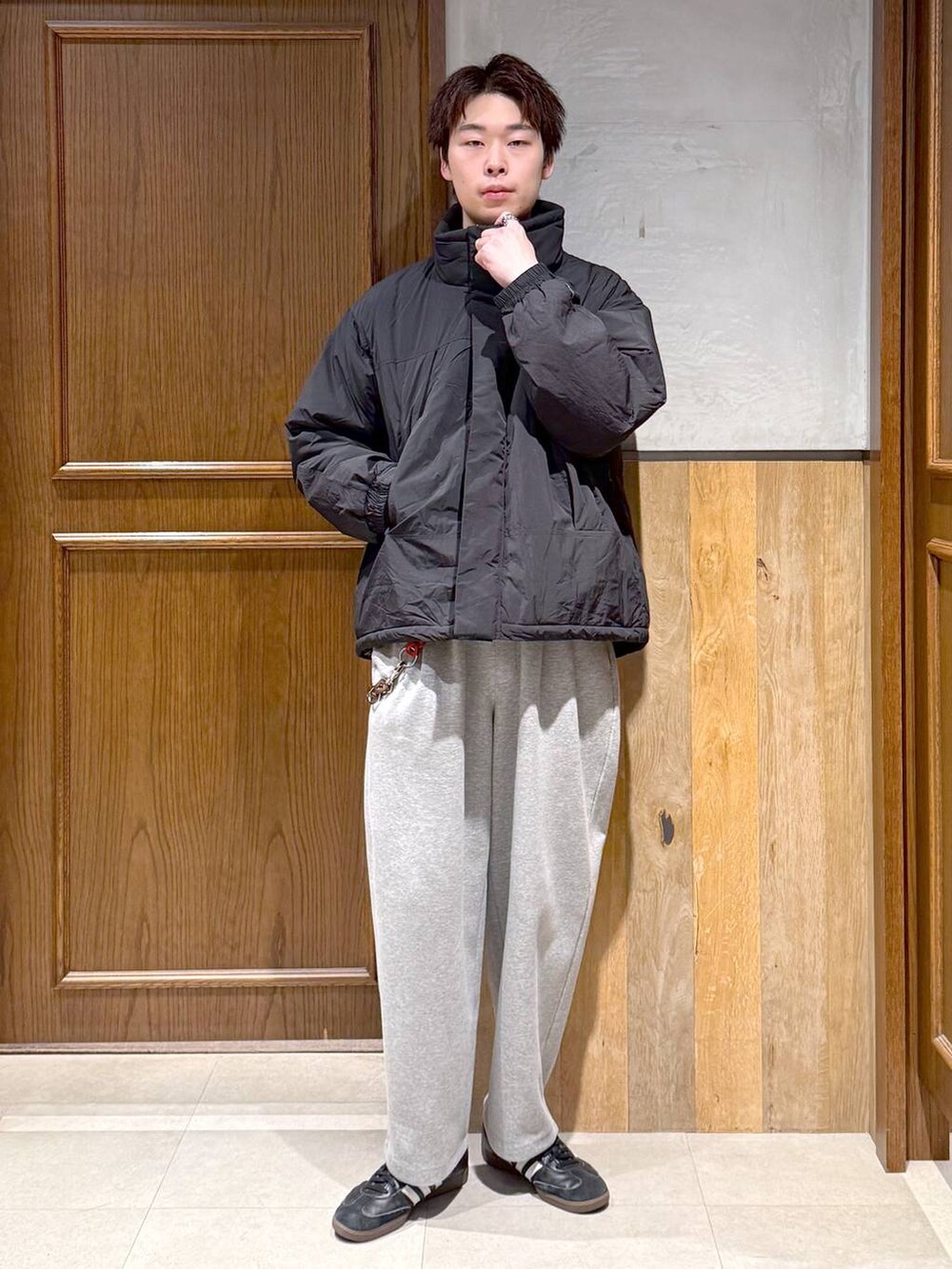 ブラック系のダウンジャケット/コート、ブルー系のニット/セーター、グレー系のスウェットパンツを着用したメンズの冬コーディネートの2枚目の写真