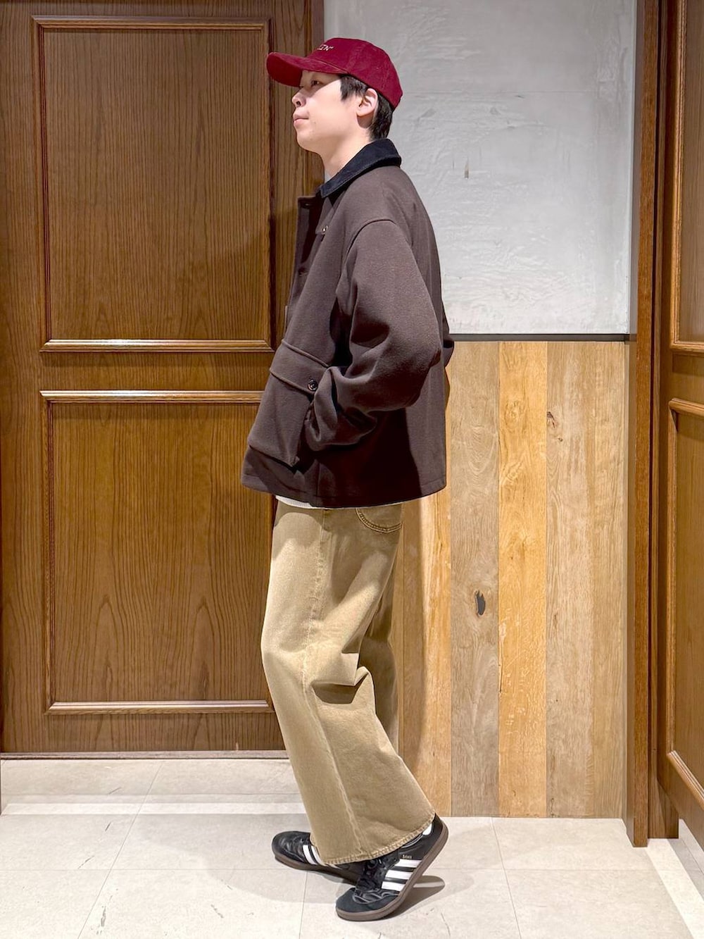 ブラウン系のブルゾン、ホワイト系のニット/セーター、ベージュ系のデニムパンツを着用したメンズの冬コーディネートの5枚目の写真