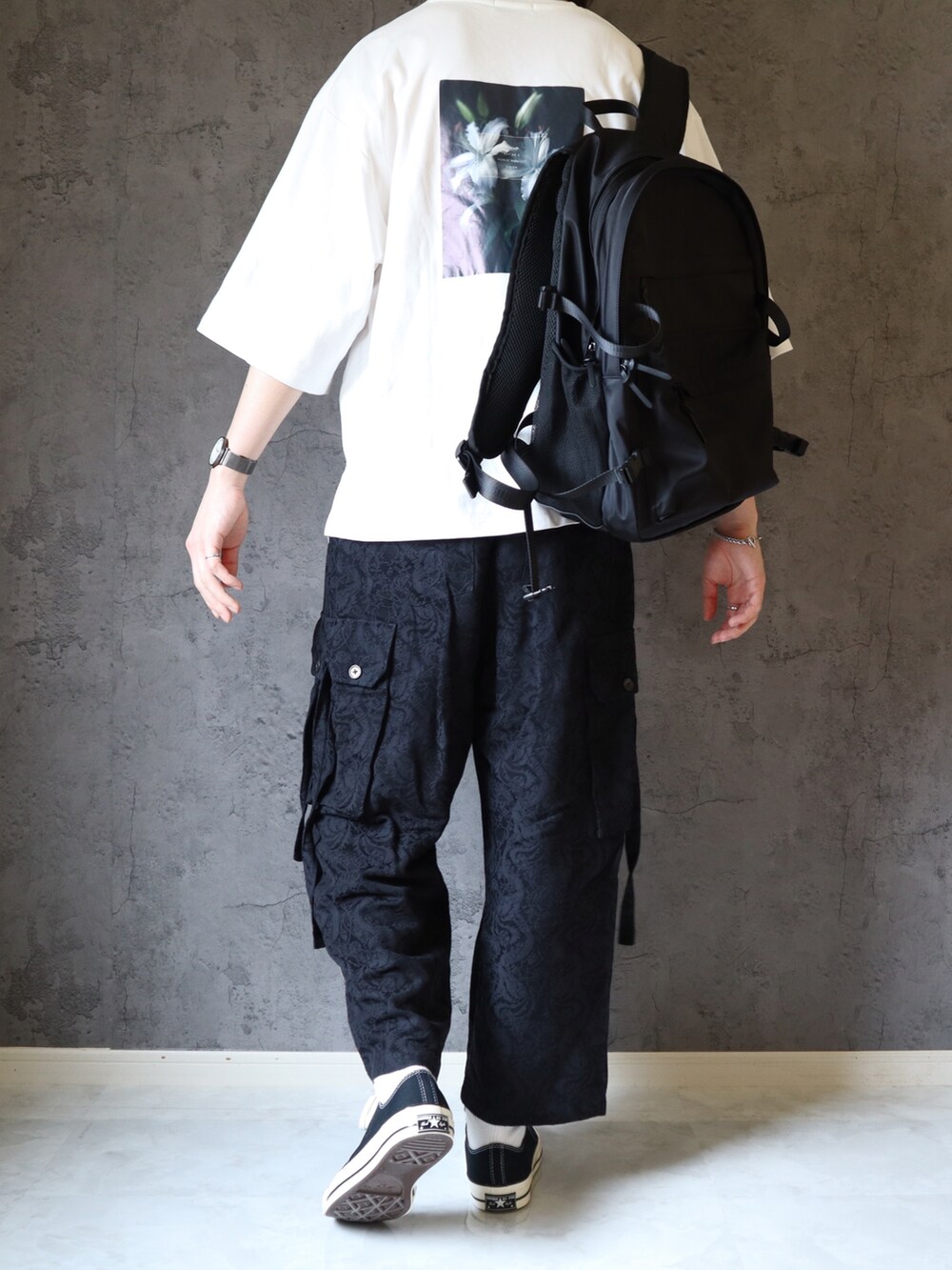 ホワイト系のTシャツ/カットソー、ブラック系のカーゴパンツ、ブラック系のスニーカーを着用したメンズの春コーディネートの4枚目の写真