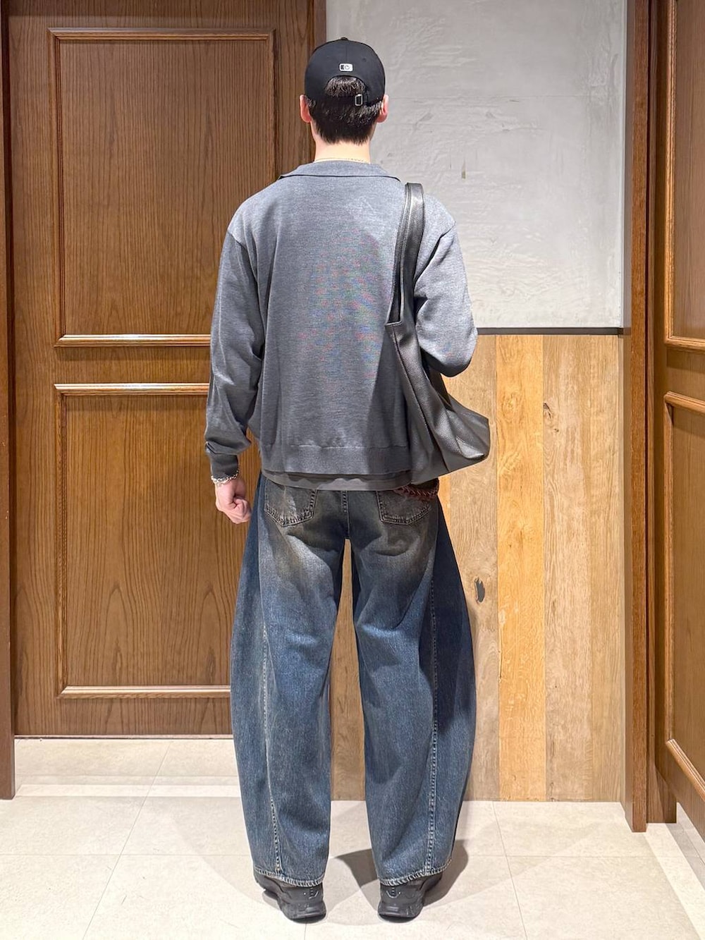 ブラック系のトートバッグ、ブルー系のデニムパンツ、グレー系のTシャツ/カットソーを着用したメンズの春コーディネートの4枚目の写真