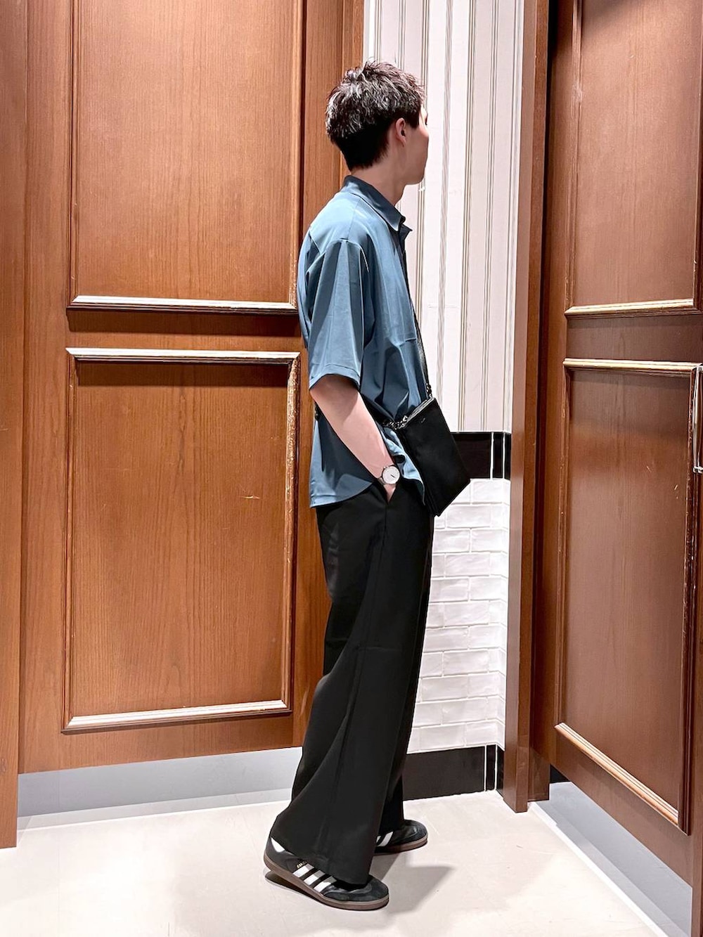 ブラック系のスラックス、ブラック系のショルダーバッグ、ブルー系のシャツ/ブラウスを着用したメンズの夏コーディネートの5枚目の写真