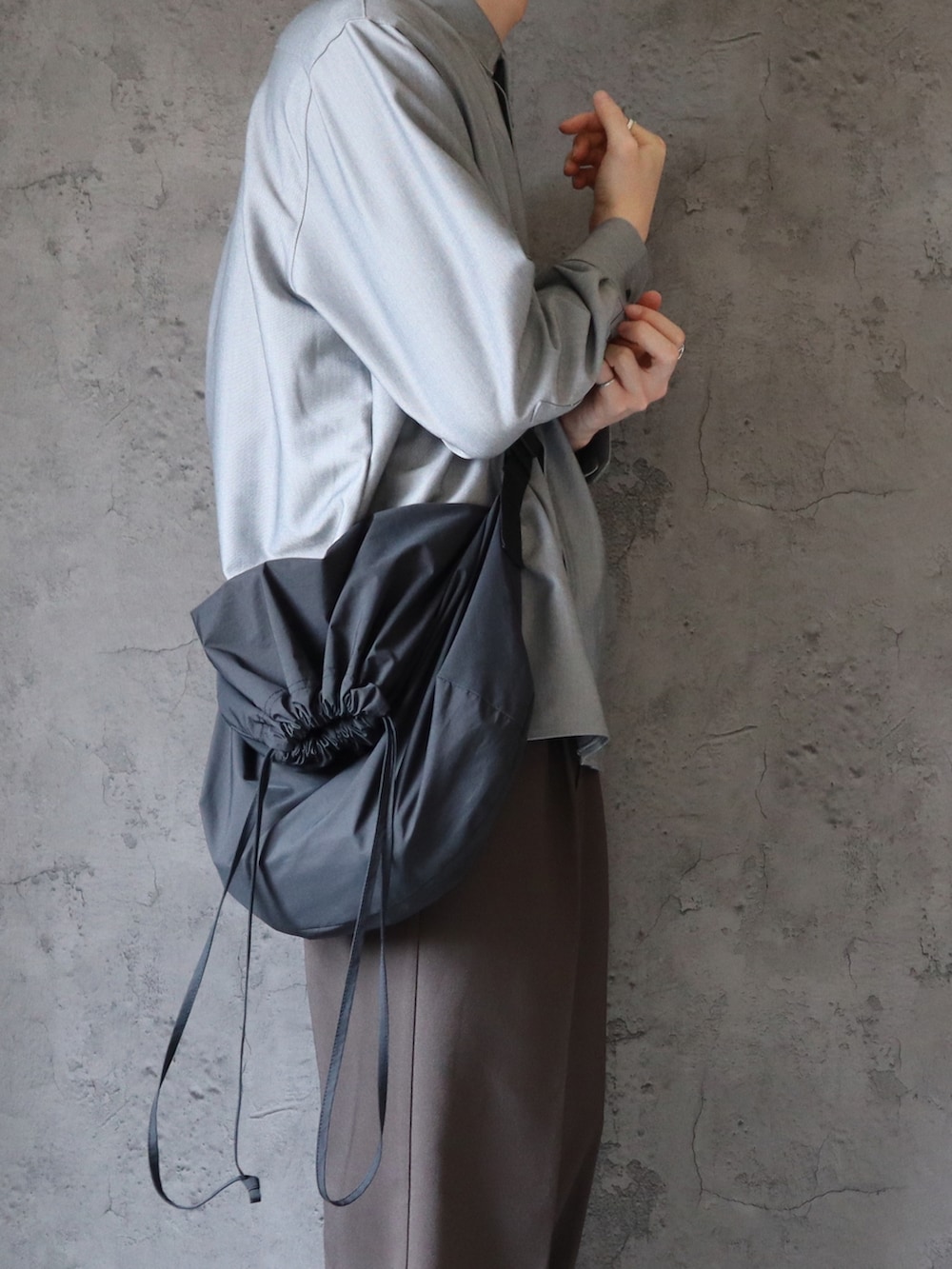 グレー系のシャツ/ブラウス、グレー系のスラックス、ブラック系のスニーカーを着用したメンズの春コーディネートの3枚目の写真