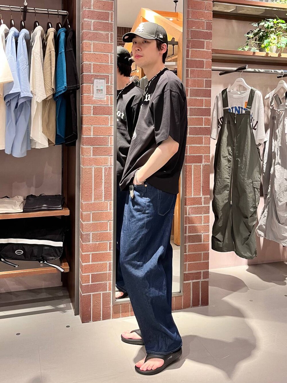 ブルー系のデニムパンツ、ブラック系のTシャツ/カットソー、パープル系のネックレスを着用したメンズの夏コーディネートの3枚目の写真