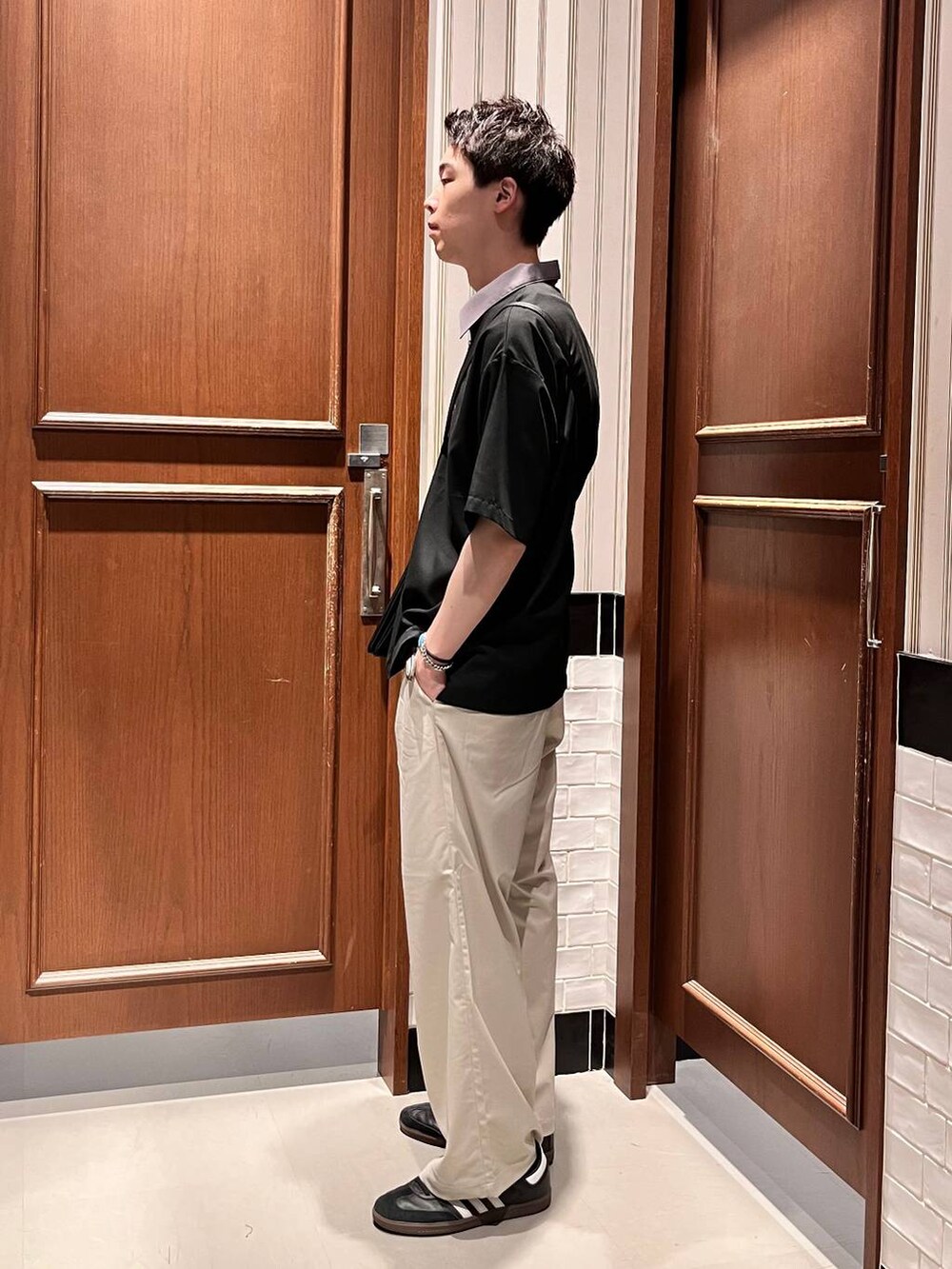 ホワイト系のスラックス、ブラック系のシャツ/ブラウス、ブラック系のショルダーバッグを着用したメンズの夏コーディネートの3枚目の写真