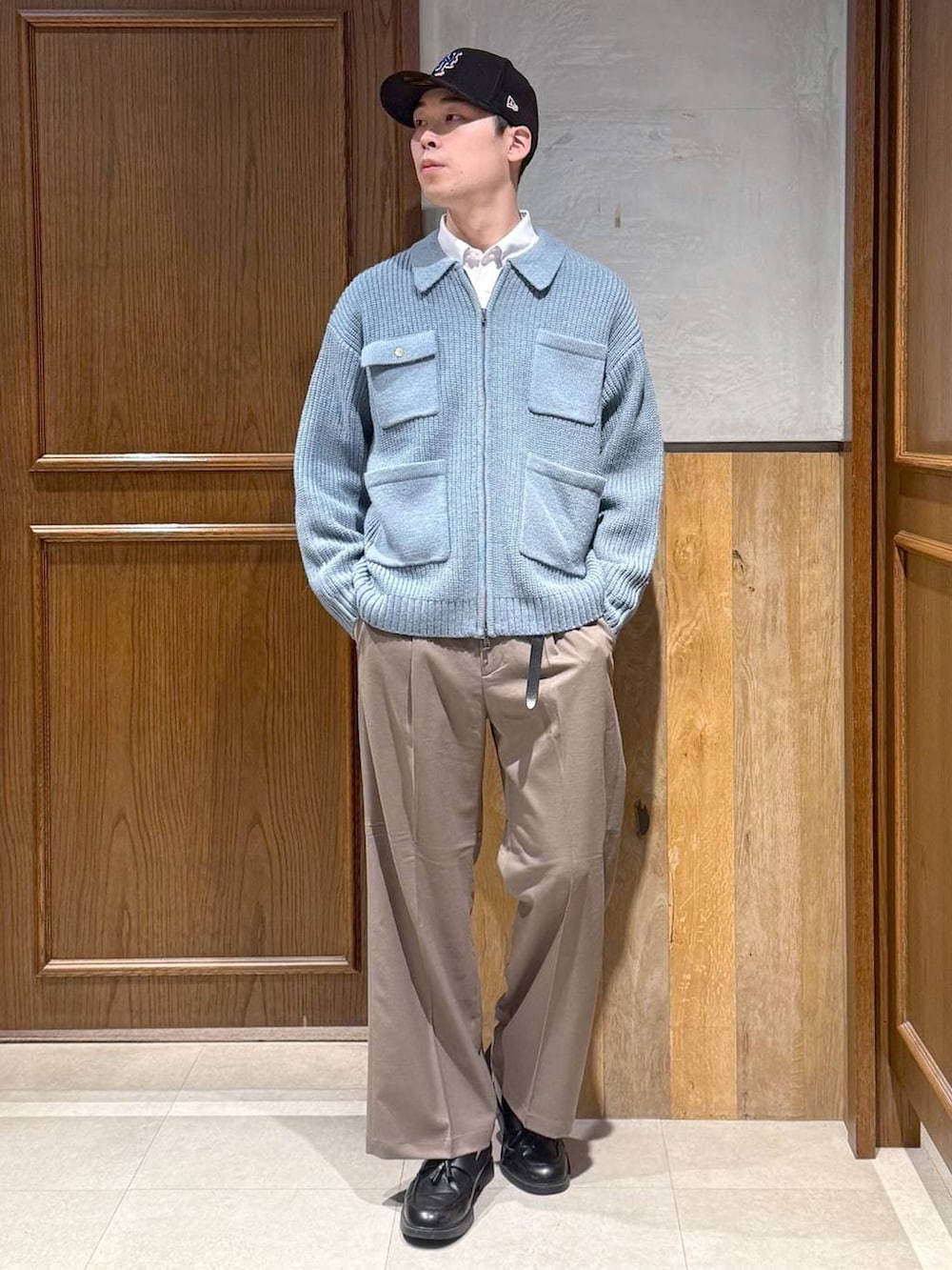 ベージュ系のスラックス、ホワイト系のシャツ/ブラウス、ブルー系のニット/セーターを着用したメンズの冬コーディネートの2枚目の写真
