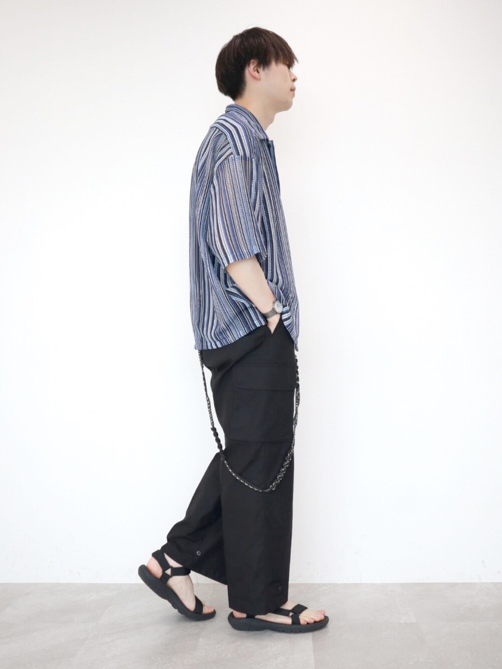 ブルー系のシャツ/ブラウス、ブラック系のカーゴパンツ、ブラック系のサンダルを着用したメンズの夏コーディネートの3枚目の写真