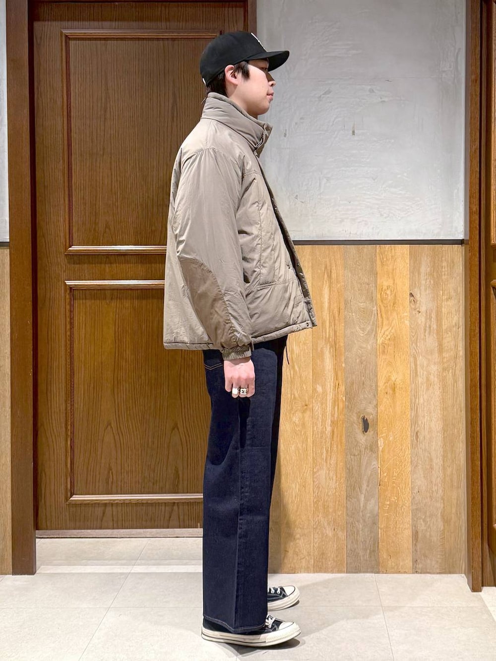 ブルー系のデニムパンツ、ブラウン系のダウンジャケット/コート、ブラウン系のニット/セーターを着用したメンズの冬コーディネートの7枚目の写真