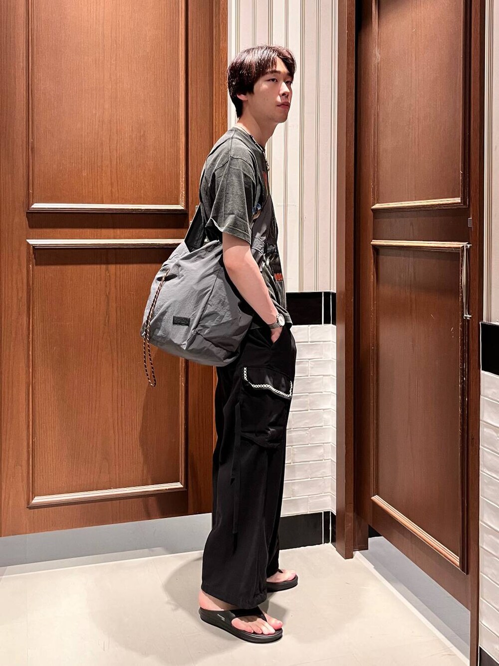 ブラック系のサンダル、ブラック系のカーゴパンツ、グレー系のショルダーバッグを着用したメンズの夏コーディネートの6枚目の写真