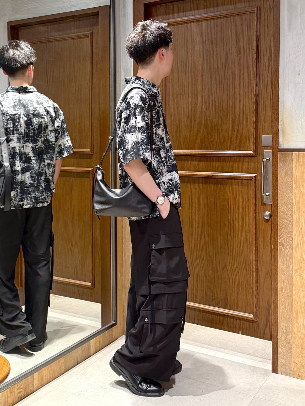 ブラック系のショルダーバッグ、ホワイト系のシャツ/ブラウス、ブラック系のカーゴパンツを着用したメンズの春コーディネートの5枚目の写真
