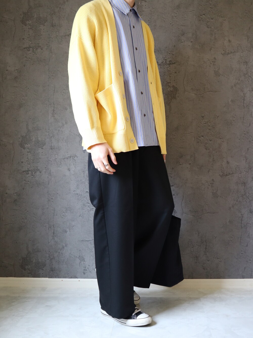 ブルー系のシャツ/ブラウス、イエロー系のニット/セーター、ブラック系のスラックスを着用したメンズの春コーディネートの5枚目の写真