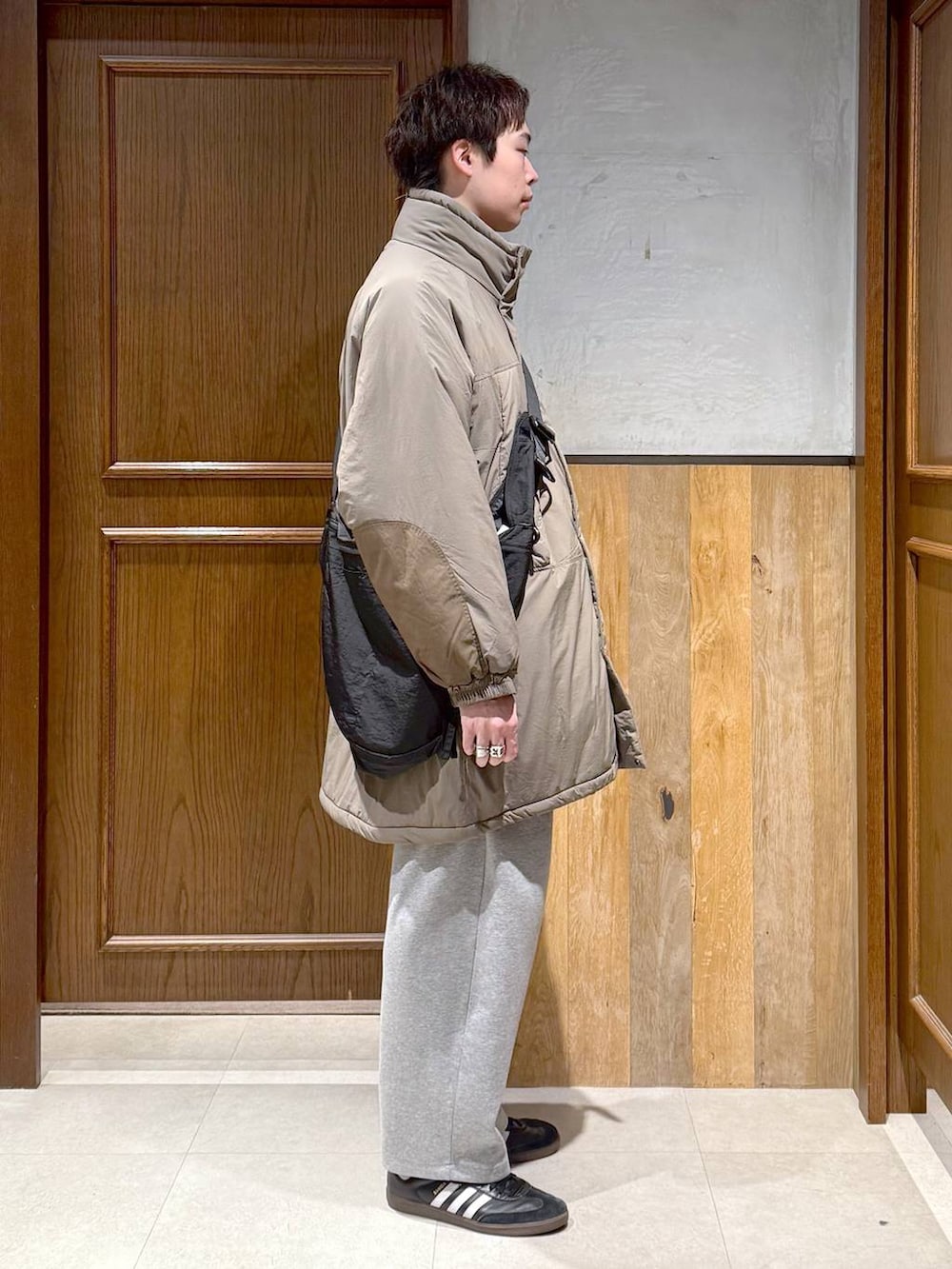 グリーン系のダウンジャケット/コート、ブラック系のポロシャツ、グレー系のスウェットパンツを着用したメンズの秋コーディネートの7枚目の写真
