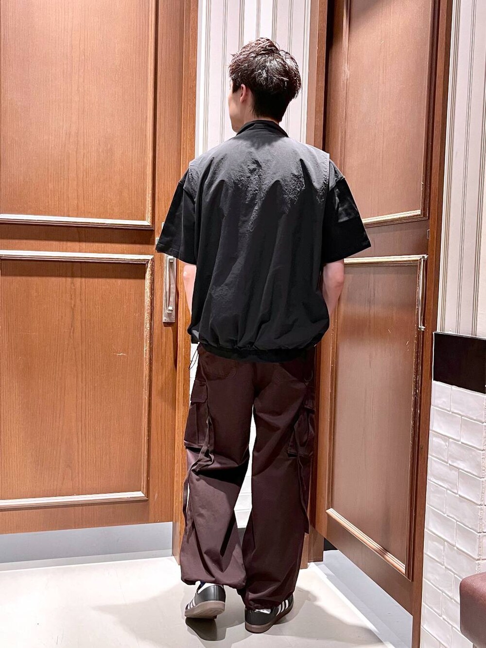 ブラウン系のカーゴパンツ、ブラック系のベスト、ブラック系のTシャツ/カットソーを着用したメンズの夏コーディネートの4枚目の写真