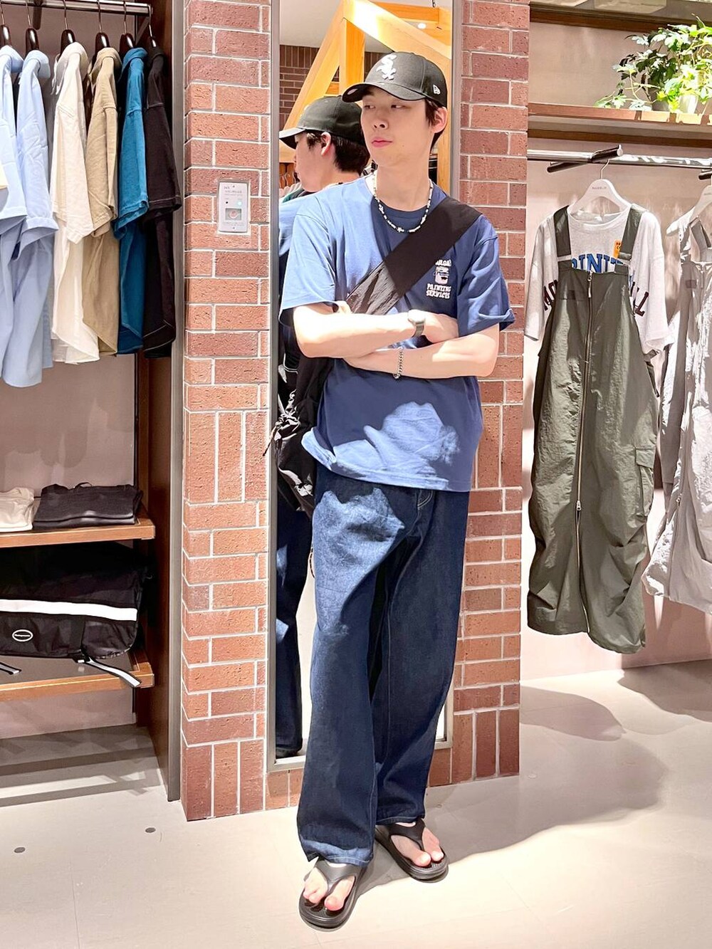 ブルー系のデニムパンツ、ブラック系のショルダーバッグ、ブルー系のTシャツ/カットソーを着用したメンズの夏コーディネートの3枚目の写真