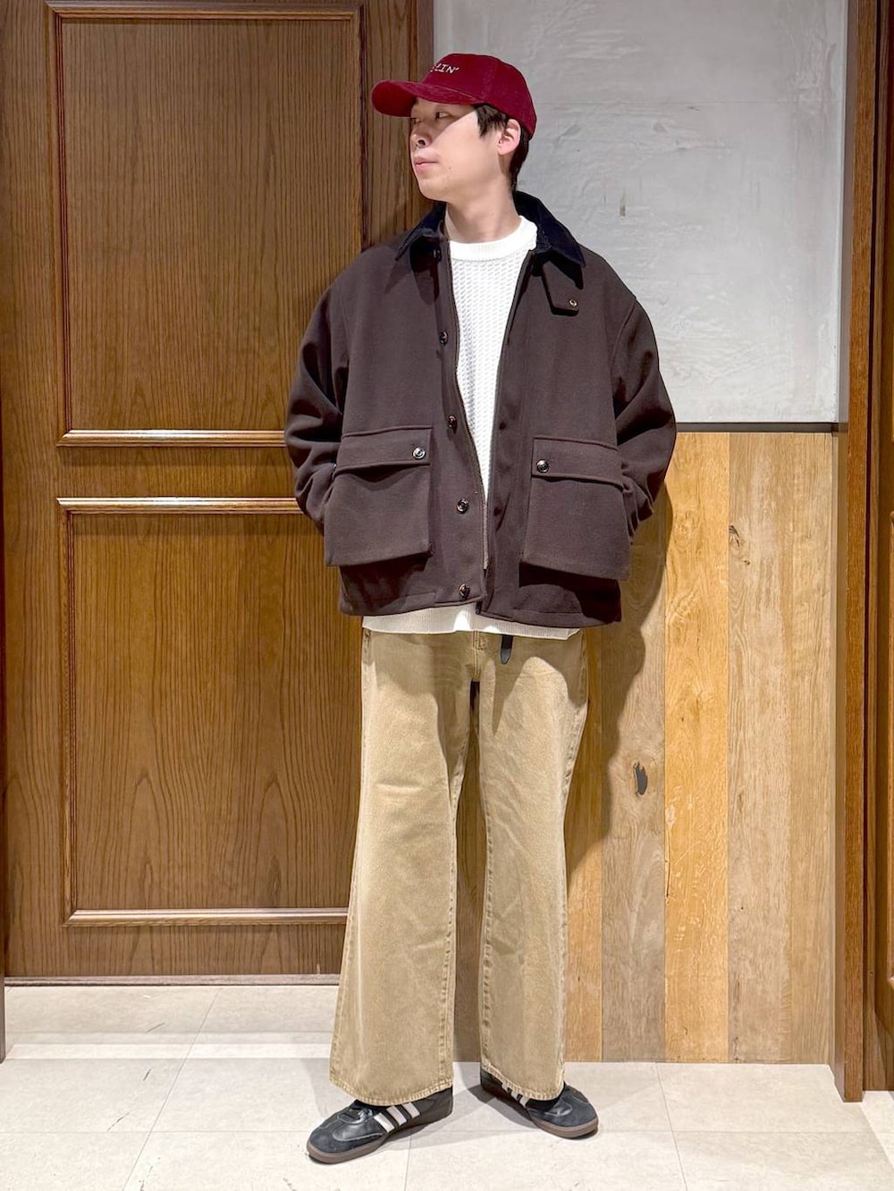ブラウン系のブルゾン、ホワイト系のニット/セーター、ベージュ系のデニムパンツを着用したメンズの冬コーディネートの8枚目の写真