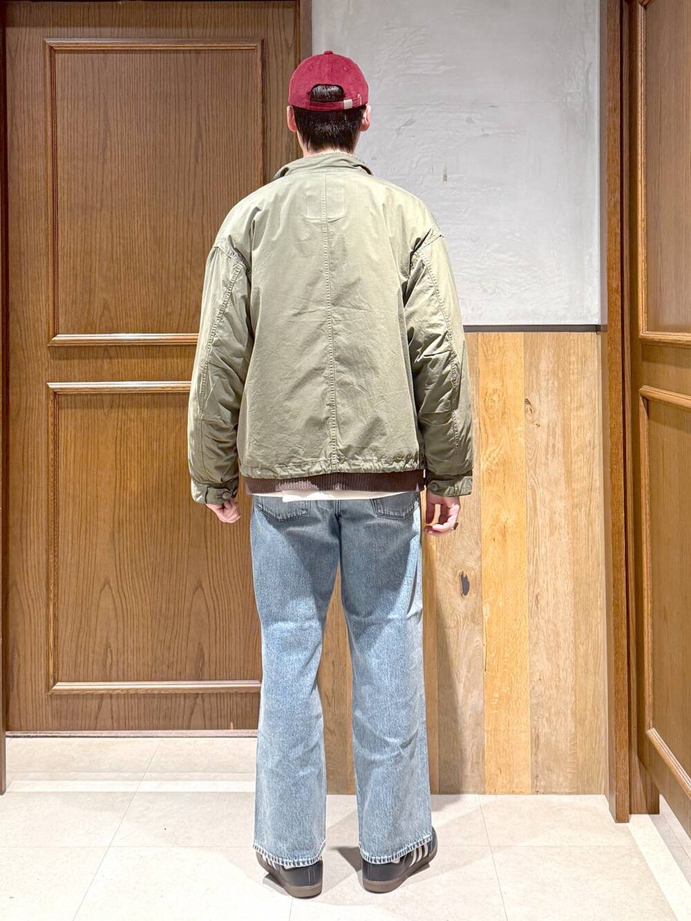 ブルー系のデニムパンツ、グリーン系のモッズコート、ブラウン系のカーディガン/ボレロを着用したメンズの秋コーディネートの6枚目の写真