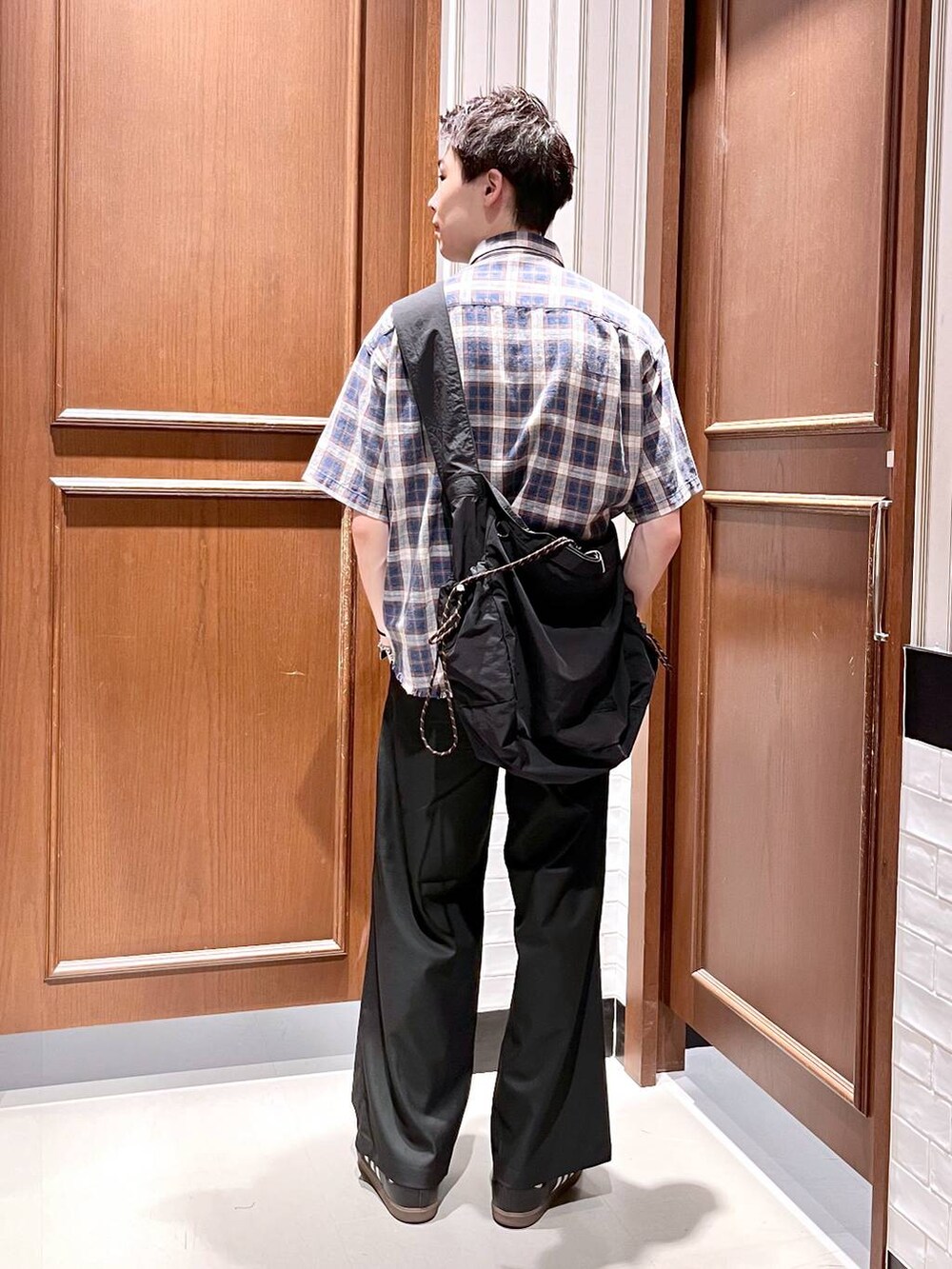 ブラック系のスラックス、ブラック系のショルダーバッグ、ブルー系のシャツ/ブラウスを着用したメンズの夏コーディネートの4枚目の写真