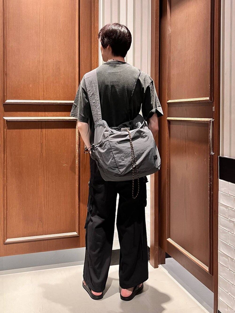 ブラック系のサンダル、ブラック系のカーゴパンツ、グレー系のショルダーバッグを着用したメンズの夏コーディネートの4枚目の写真