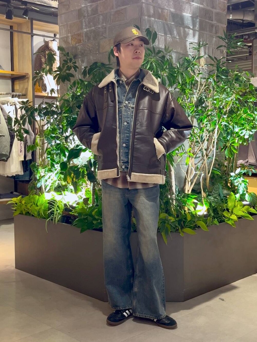 ブラウン系のムートンコート、ブルー系のデニムパンツ、ブルー系のデニムジャケットを着用したメンズの冬コーディネートの2枚目の写真