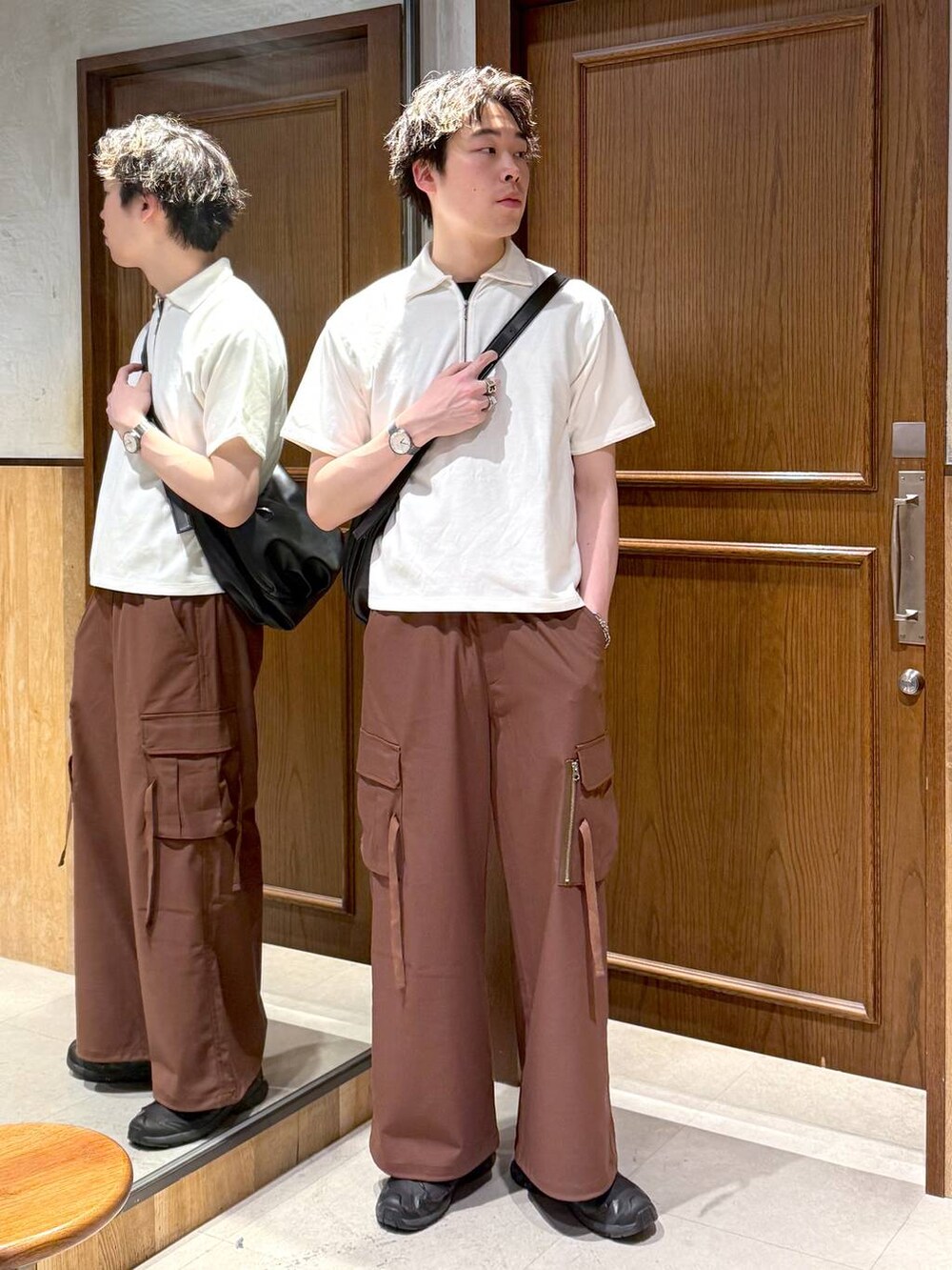 ブラック系のショルダーバッグ、イエロー系のスラックス、ホワイト系のTシャツ/カットソーを着用したメンズの春コーディネートの2枚目の写真