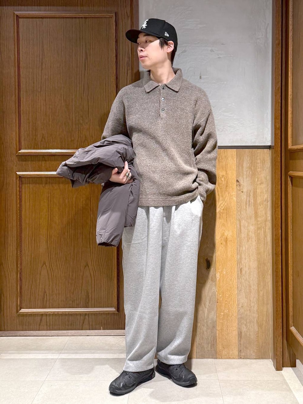 グレー系のダウンジャケット/コート、ベージュ系のポロシャツ、グレー系のスウェットパンツを着用したメンズの冬コーディネートの2枚目の写真