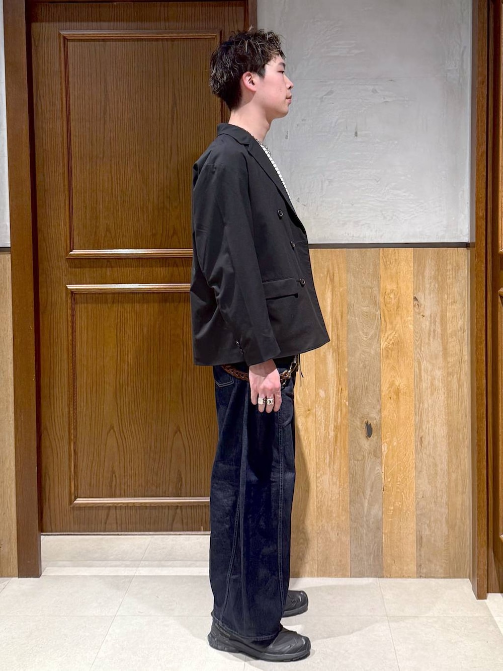 ブラック系のテーラードジャケット、ホワイト系のTシャツ/カットソー、ブルー系のデニムパンツを着用したメンズの春コーディネートの5枚目の写真