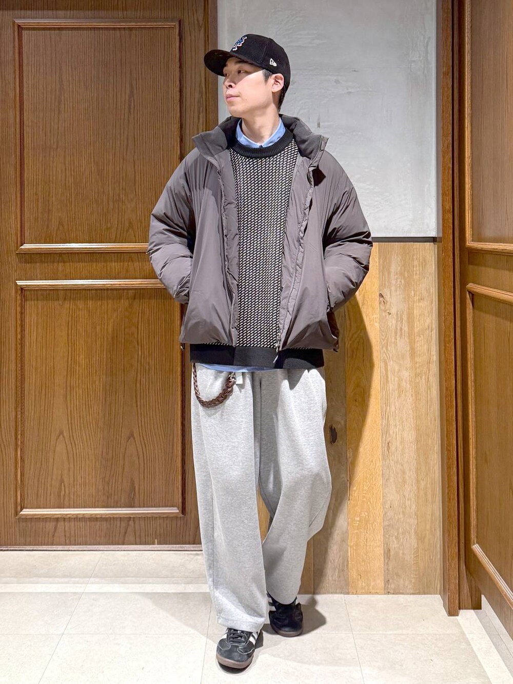 グレー系のダウンジャケット/コート、ブラック系のニット/セーター、グレー系のスウェットパンツを着用したメンズの秋コーディネートの2枚目の写真