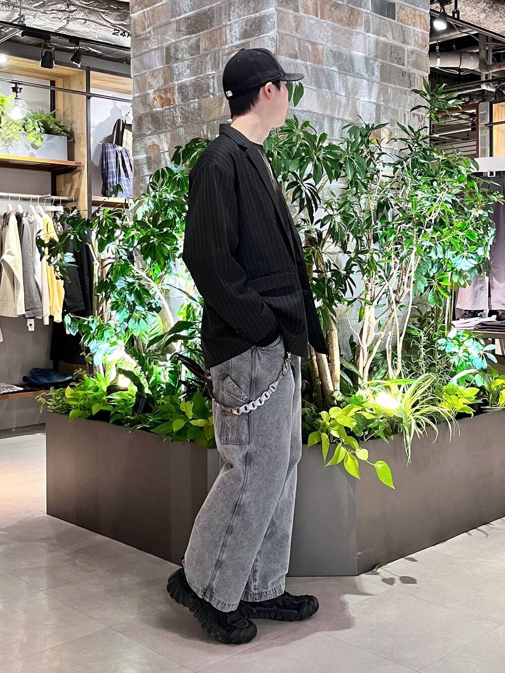 グレー系のデニムパンツ、ブラック系のテーラードジャケット、ブラック系のTシャツ/カットソーを着用したメンズの春コーディネートの4枚目の写真