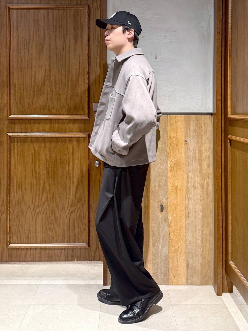 ベージュ系のブルゾン、ブラック系のニット/セーター、ブラック系のスラックスを着用したメンズの冬コーディネートの4枚目の写真