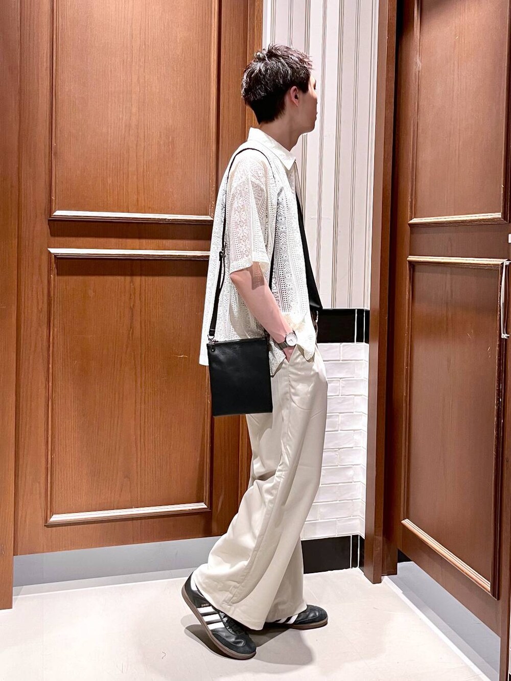 ホワイト系のスラックス、ブラック系のショルダーバッグ、ホワイト系のシャツ/ブラウスを着用したメンズの夏コーディネートの3枚目の写真