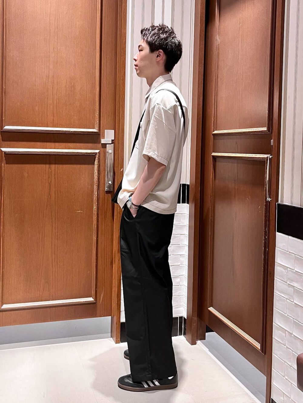 ブラック系のスラックス、ブラック系のショルダーバッグ、ホワイト系のシャツ/ブラウスを着用したメンズの夏コーディネートの5枚目の写真