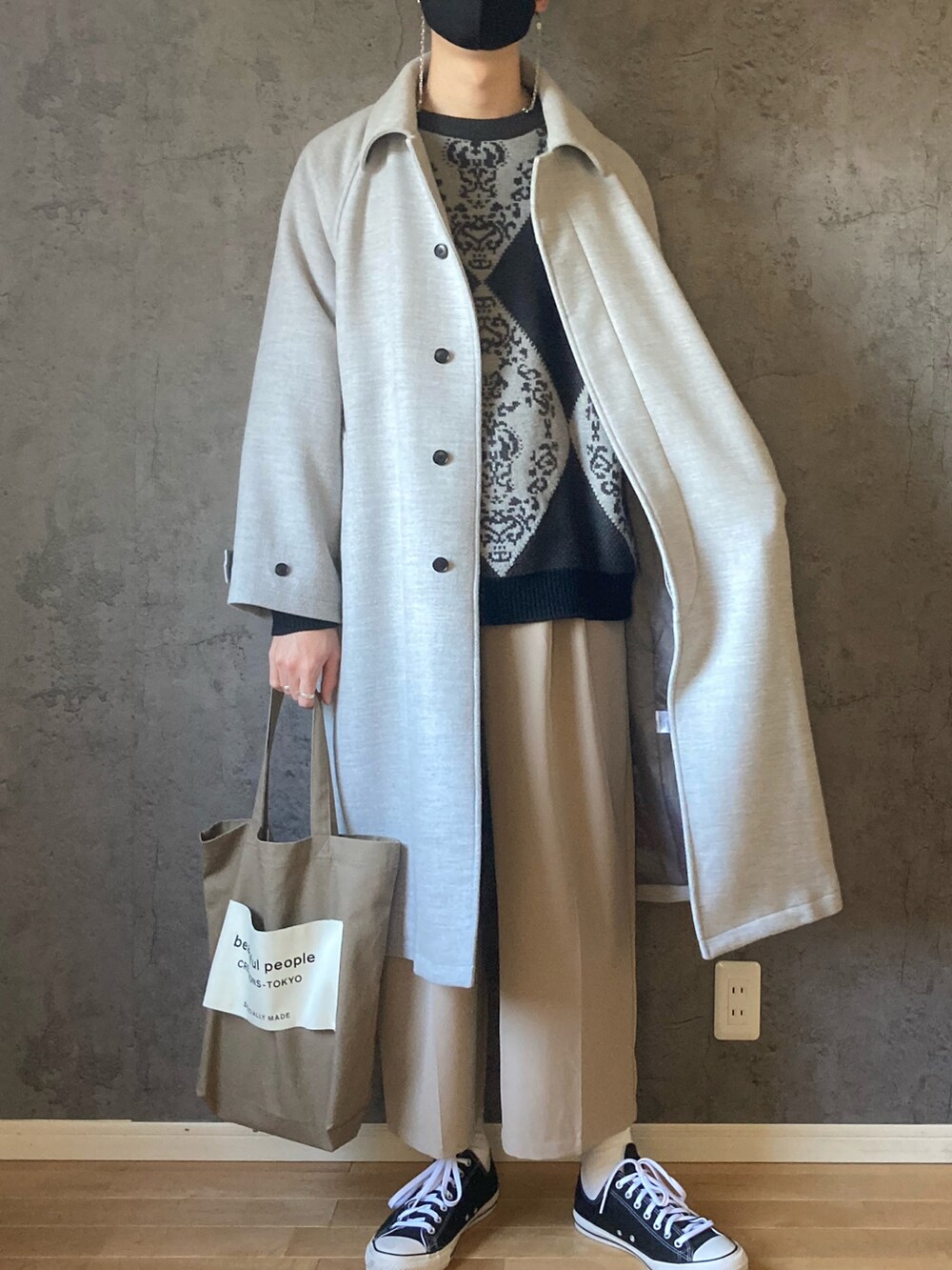 グレー系のニット/セーター、グレー系のその他アウター、ブラウン系のスラックスを着用したメンズの冬コーディネートの2枚目の写真