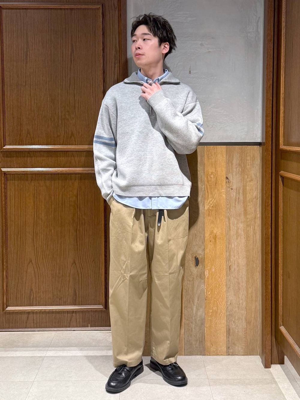 ブルー系のシャツ/ブラウス、ベージュ系のチノパンツ、グレー系のニット/セーターを着用したメンズの冬コーディネートの6枚目の写真