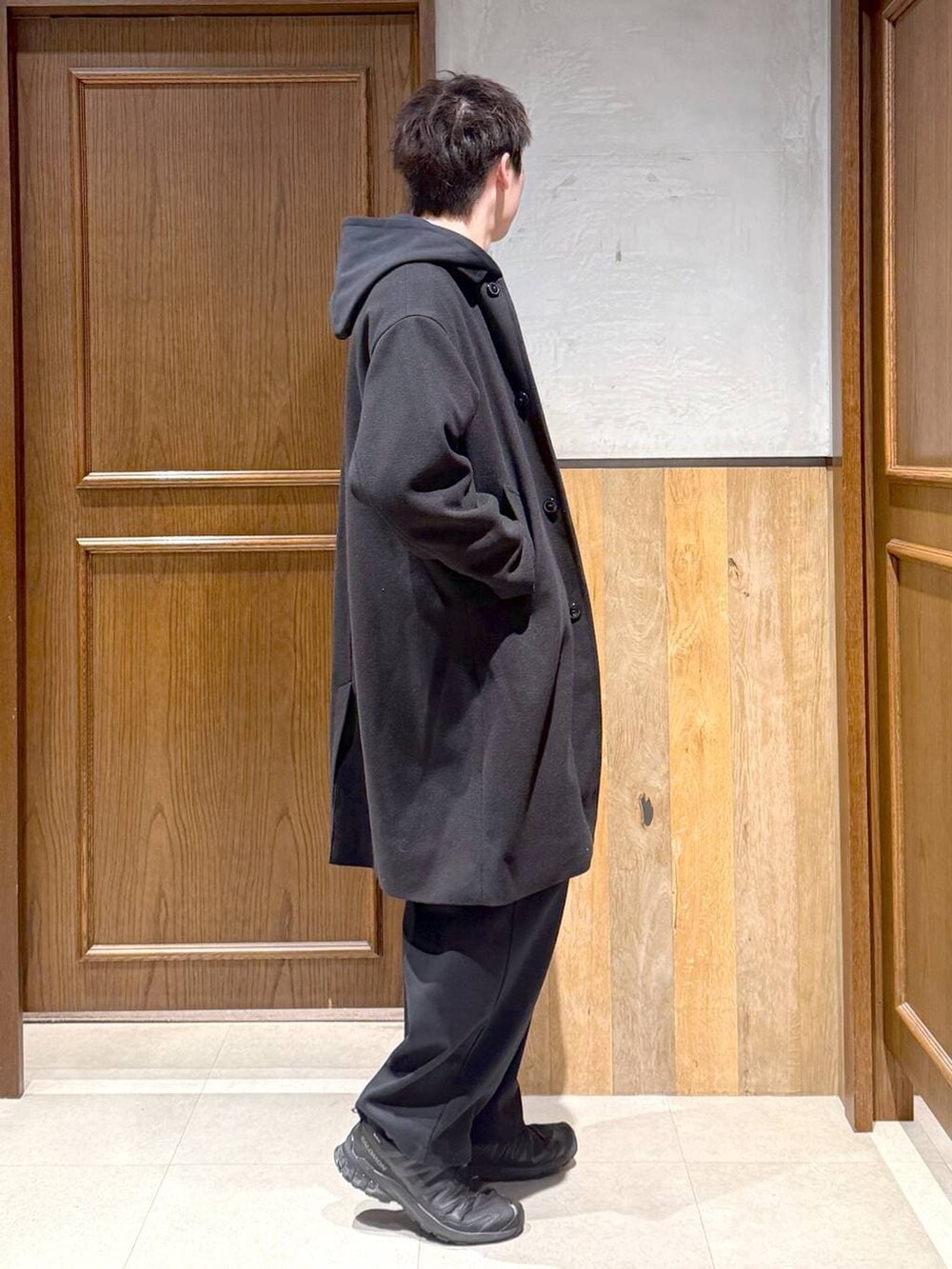 ブラック系のトレンチコート、ブルー系のシャツ/ブラウス、ブラック系のパーカーを着用したメンズの秋コーディネートの6枚目の写真