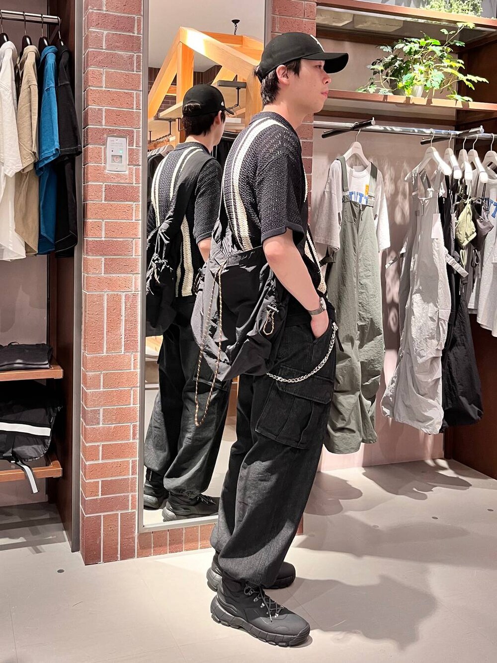 グレー系のデニムパンツ、ブラック系のショルダーバッグ、ブラック系のニット/セーターを着用したメンズの夏コーディネートの4枚目の写真