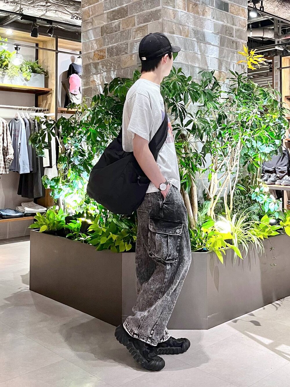ブラック系のショルダーバッグ、グレー系のデニムパンツ、ホワイト系のTシャツ/カットソーを着用したメンズの春コーディネートの5枚目の写真