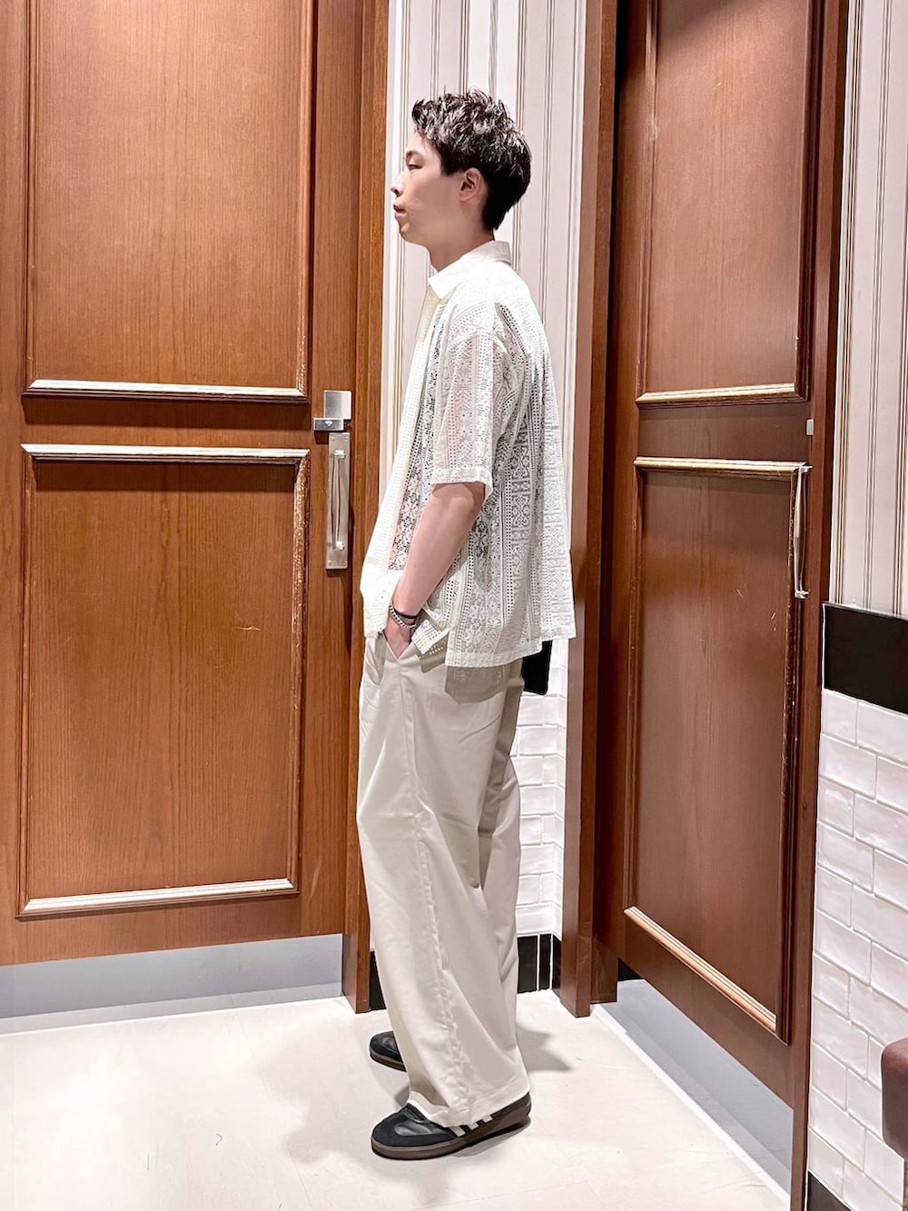 ホワイト系のスラックス、ブラック系のショルダーバッグ、ホワイト系のシャツ/ブラウスを着用したメンズの夏コーディネートの5枚目の写真