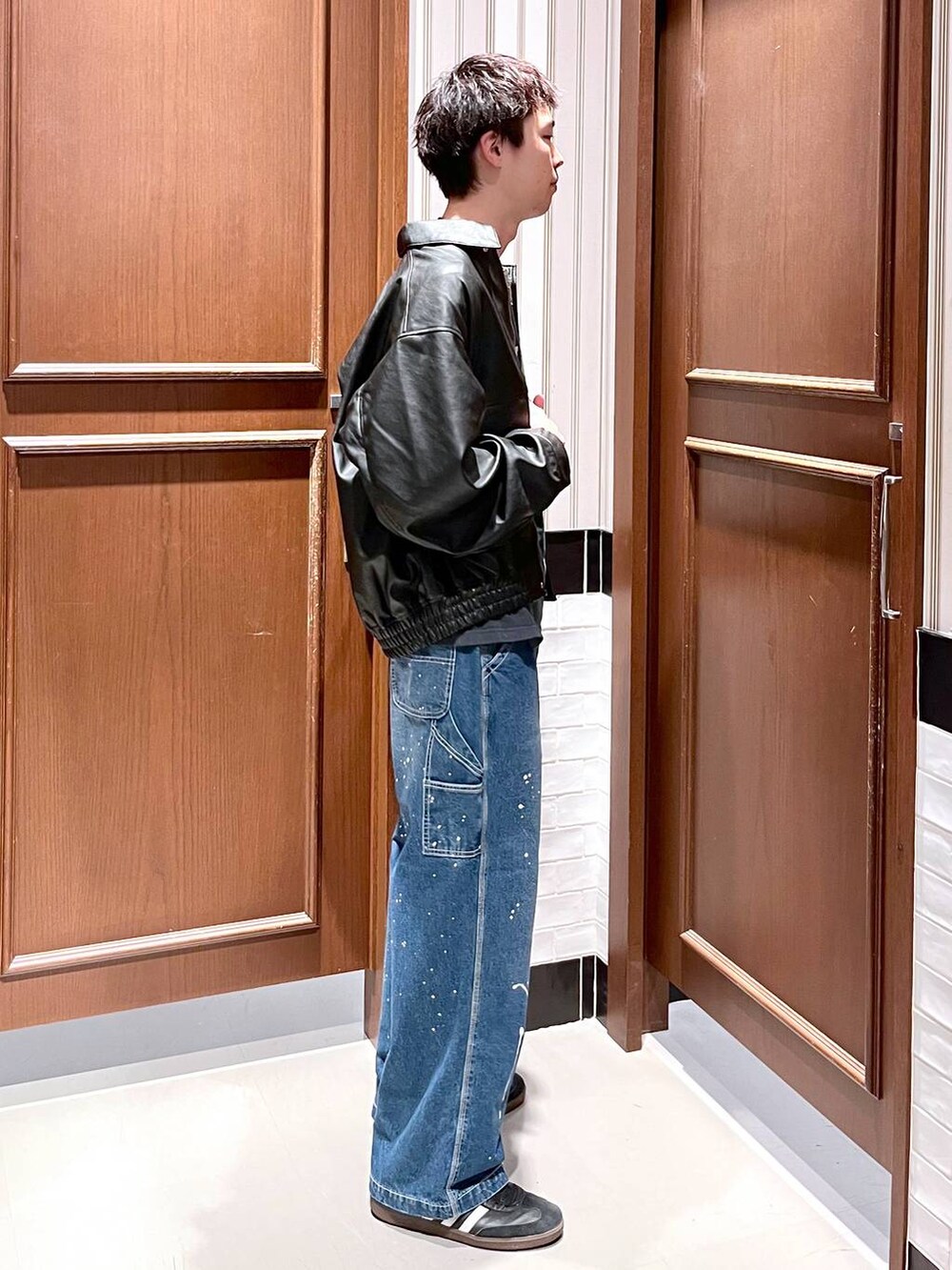 ブラック系のブルゾン、ブルー系のデニムパンツを着用したメンズの夏コーディネートの3枚目の写真