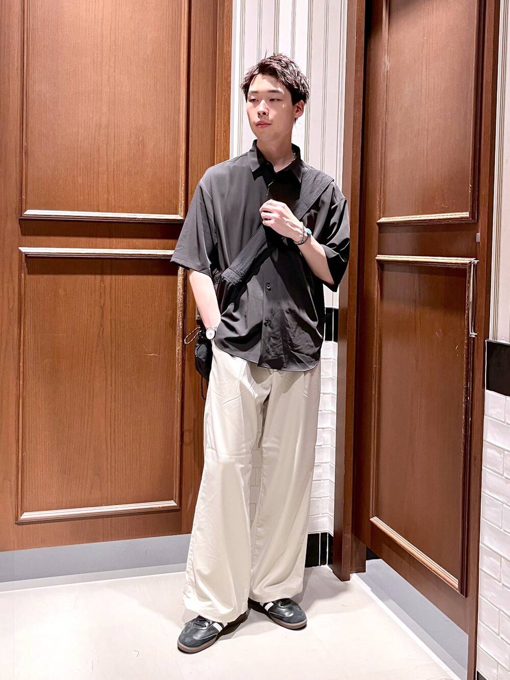 ホワイト系のスラックス、ブラック系のシャツ/ブラウス、ブラック系のショルダーバッグを着用したメンズの夏コーディネートの2枚目の写真