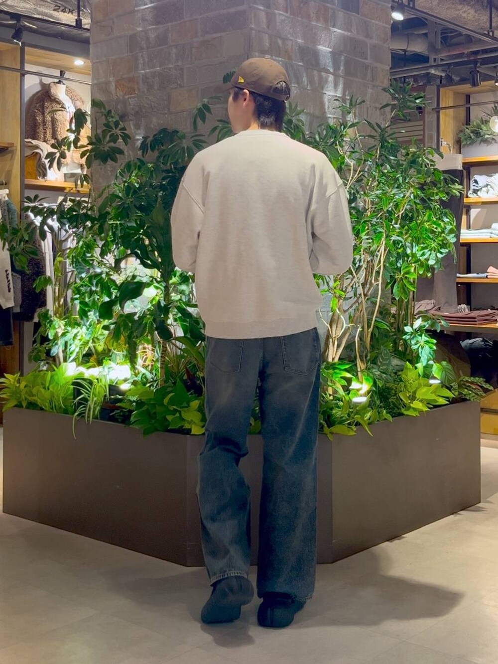 ブルー系のデニムパンツ、ホワイト系のスウェット、ブラウン系のキャップを着用したメンズの冬コーディネートの5枚目の写真