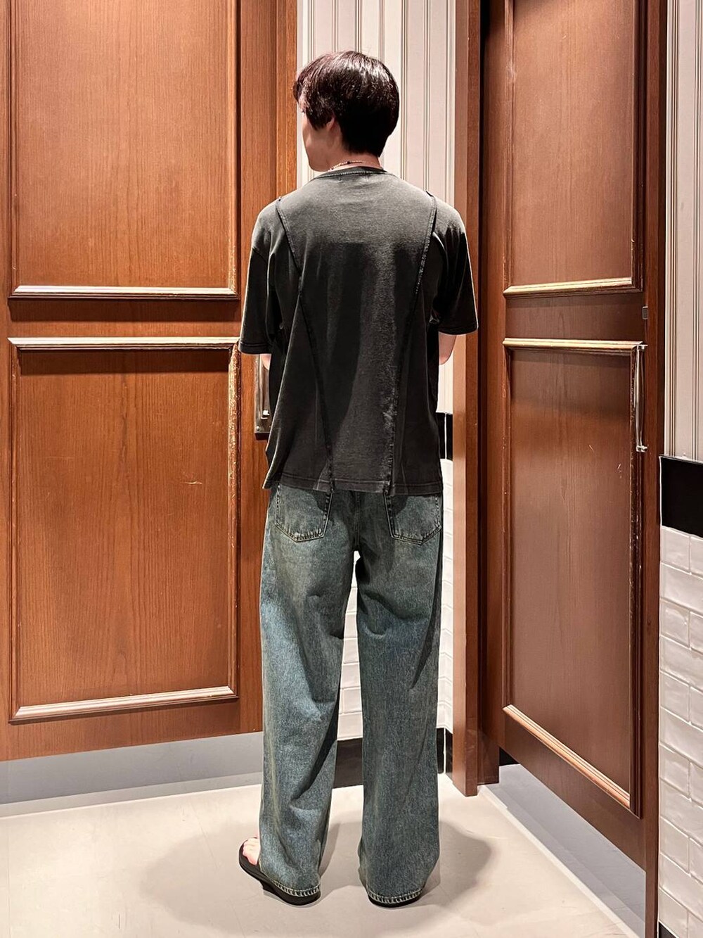 ブラック系のサンダル、ブルー系のデニムパンツ、グレー系のTシャツ/カットソーを着用したメンズの夏コーディネートの5枚目の写真